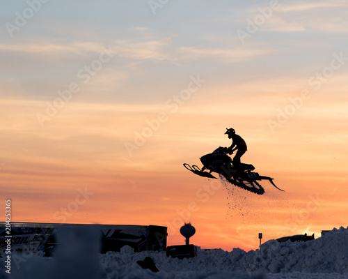 Snowmobile Jumping into Sunset Sky