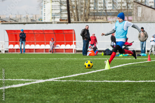 Boy kicking soccer ball on sports field © olinchuk