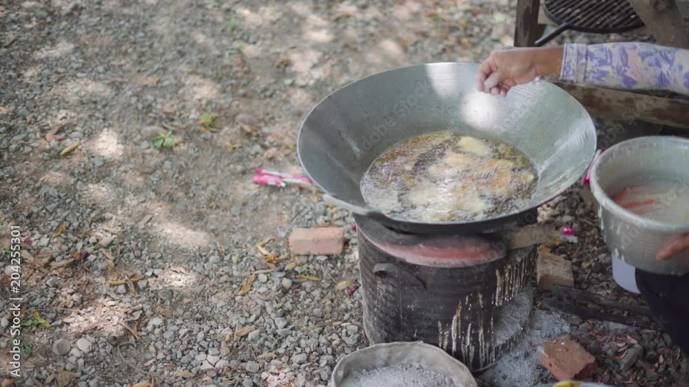 Thai fried banana snack cooking on an oil pan over Asian traditional charcoal stove Thai fried banana snack cooking on an oil pan over Asian traditional charcoal stove
