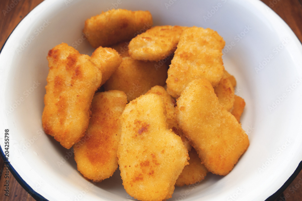 Appetizing, bright and beautiful chicken nuggets in an iron bowl Appetizing, bright and beautiful chicken nuggets in an iron bowl