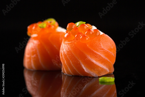salmon sushi with caviar on the black background