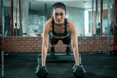 Beautiful asian woman play fitness in the gym,Thailand girl has a slim body,Time for exercise,People love heath,Stretching body before workout,Sport woman warm up body,push up with dumbell
