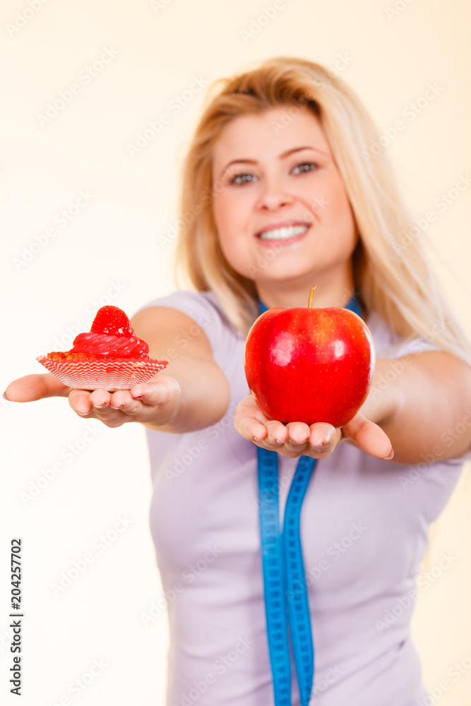 Woman with measuring tape choosing what to eat Woman with measuring tape choosing what to eat