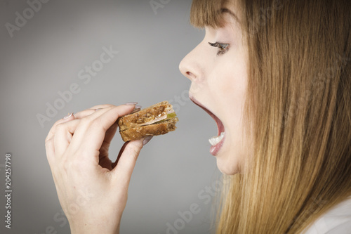Woman eating sandwich  taking bite