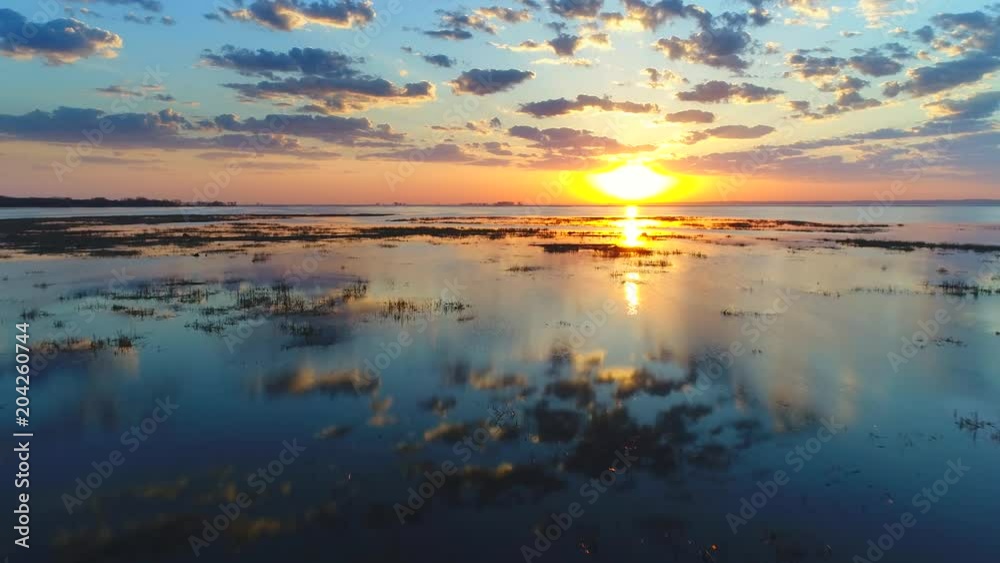 Amazing sunrise reflected in marsh waters in Springtime, moving aerial perspective.
Amazing sunrise reflected in marsh waters in Springtime, moving aerial perspective.