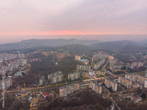 beautiful cityscape with sunrise. red sun rise above the mountains © phpetrunina14