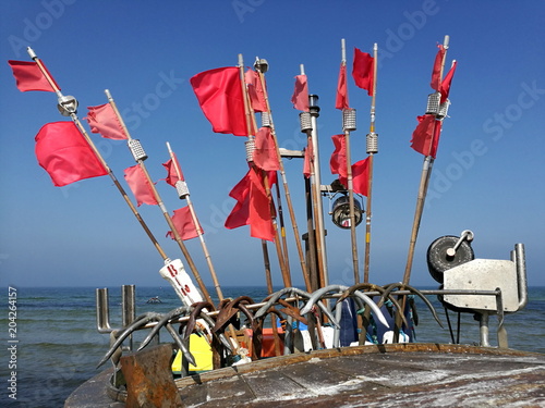 Bojen mit roten Fahnen vor blauem Himmel im Sonnenschein auf einem Fischerboot am Strand von Binz auf der Insel Rügen an der Ostsee in Mecklenburg-Vorpommern photo