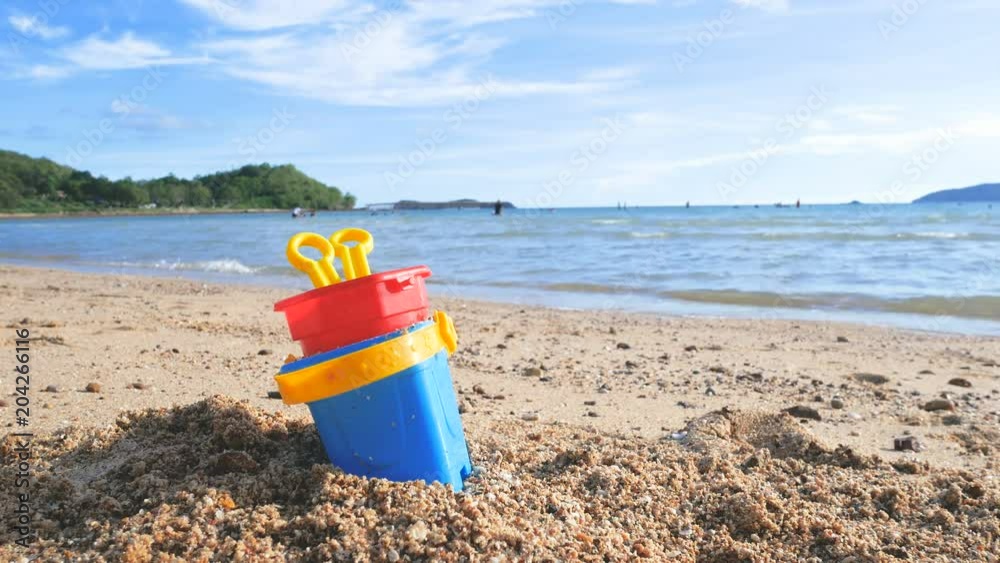 Toys on the sand beach with sea wave select focus shallow depth of field with summer atmosphere Toys on the sand beach with sea wave select focus shallow depth of field with summer atmosphere