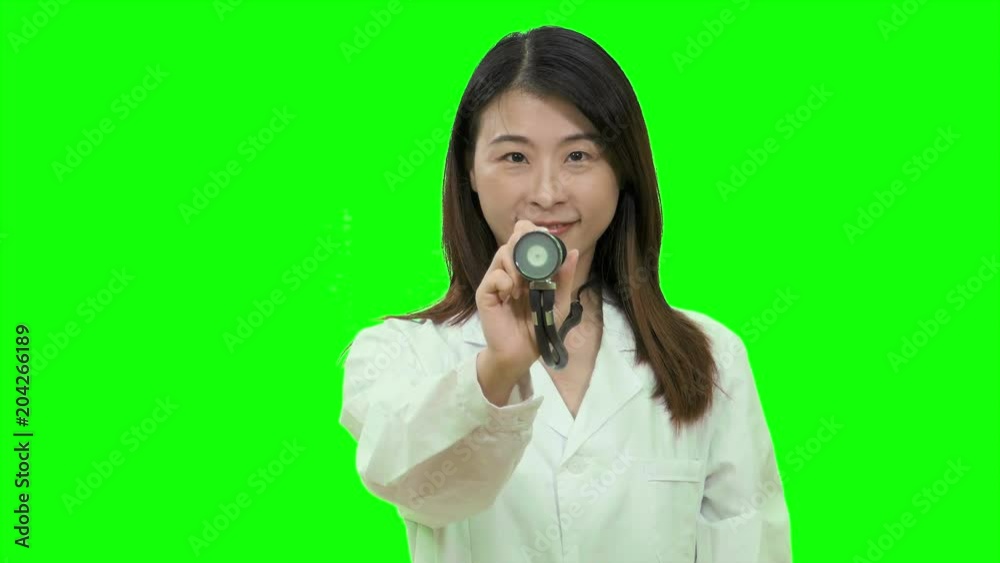 Asian female doctor holding stethoscope out up on Green Screen Asian female doctor holding stethoscope out up on Green Screen