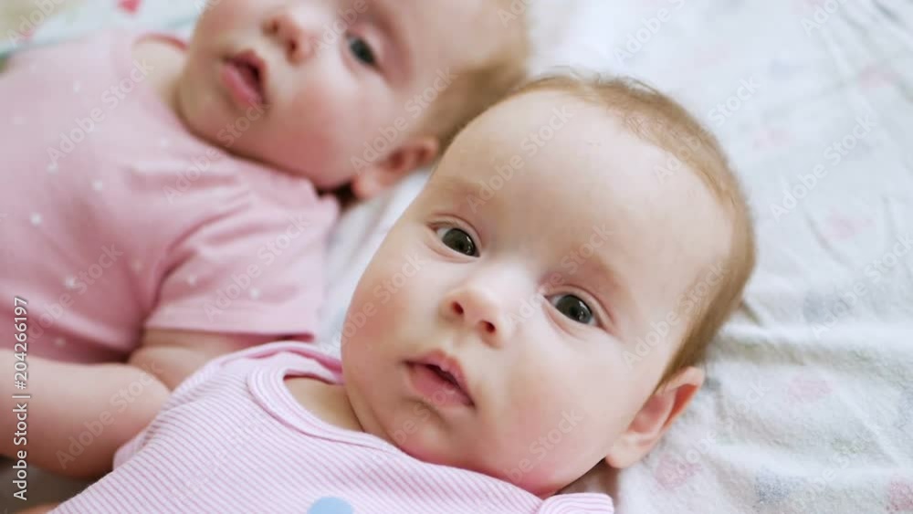 girls twin sisters in pink clothes lying on the bed girls twin sisters in pink clothes lying on the bed