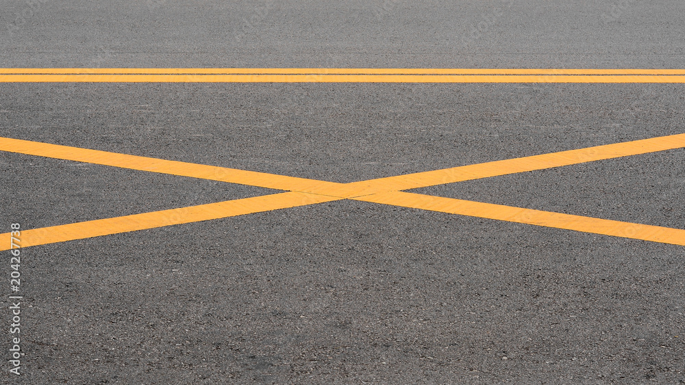 abstract yellow painted line on asphalt road - background