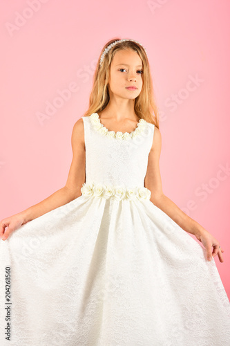 Fashion model on pink background, beauty. Child girl in stylish glamour dress, elegance. Look, hairdresser, makeup. Fashion and beauty, little princess. Little girl in fashionable dress, prom.