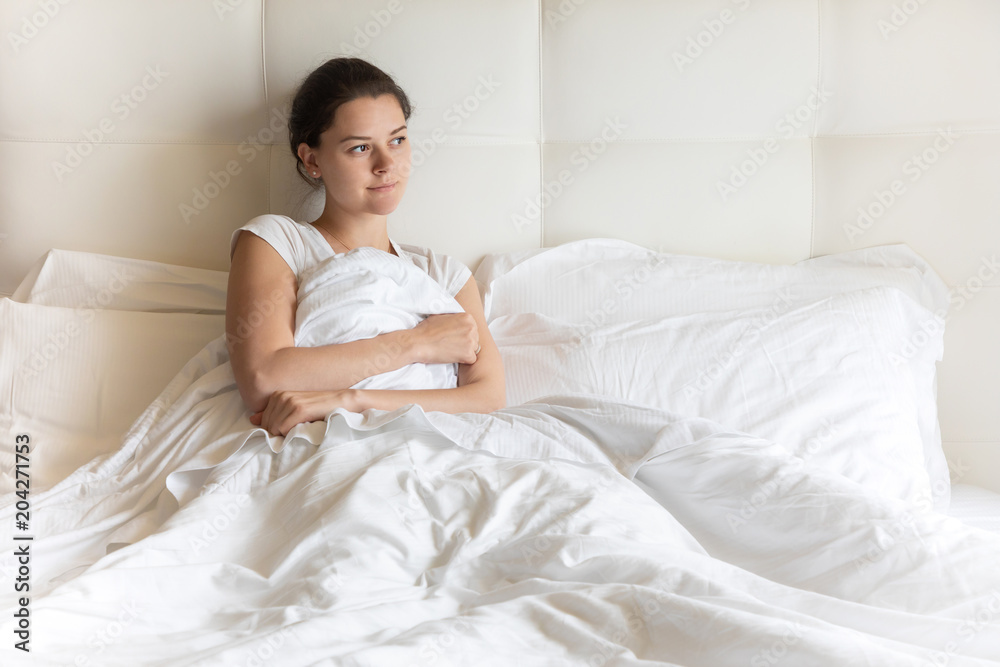 Portrait pretty young girl on bed in modern apartment in the morning Portrait pretty young girl on bed in modern apartment in the morning