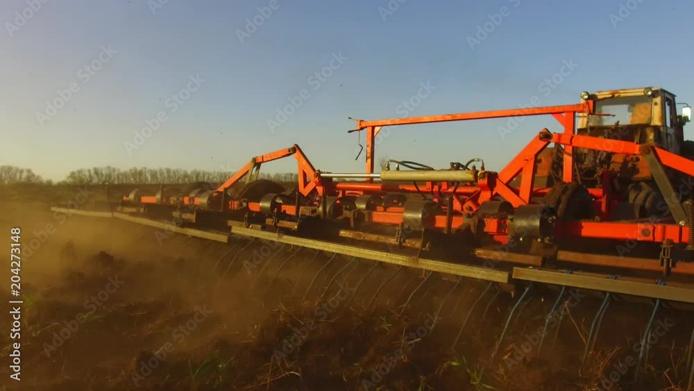 Farmer in tractor soil plows steadicam motion agriculture the ground Russia preparing land with seedbed cultivator as part of pre lifestyle seeding activities in early spring season of agricultural Farmer in tractor soil plows steadicam motion agriculture the ground Russia preparing land with seedbed cultivator as part of pre lifestyle seeding activities in early spring season of agricultural