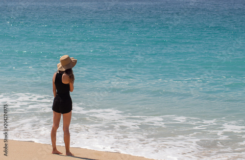 Wallpaper Mural Young woman wearing a hat at the beach and standing by the seashore in Mexico Torontodigital.ca