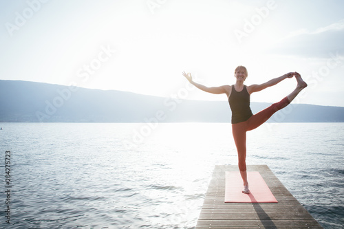 Woman doing exercise at the beach on pier photo