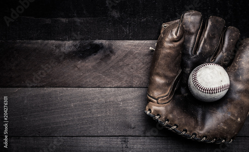 Photography A group of vintage baseball equipment, bats, gloves, baseballs on wooden backgro