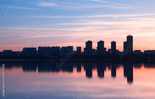 Modern skyscrapers meeting sunset light rays background