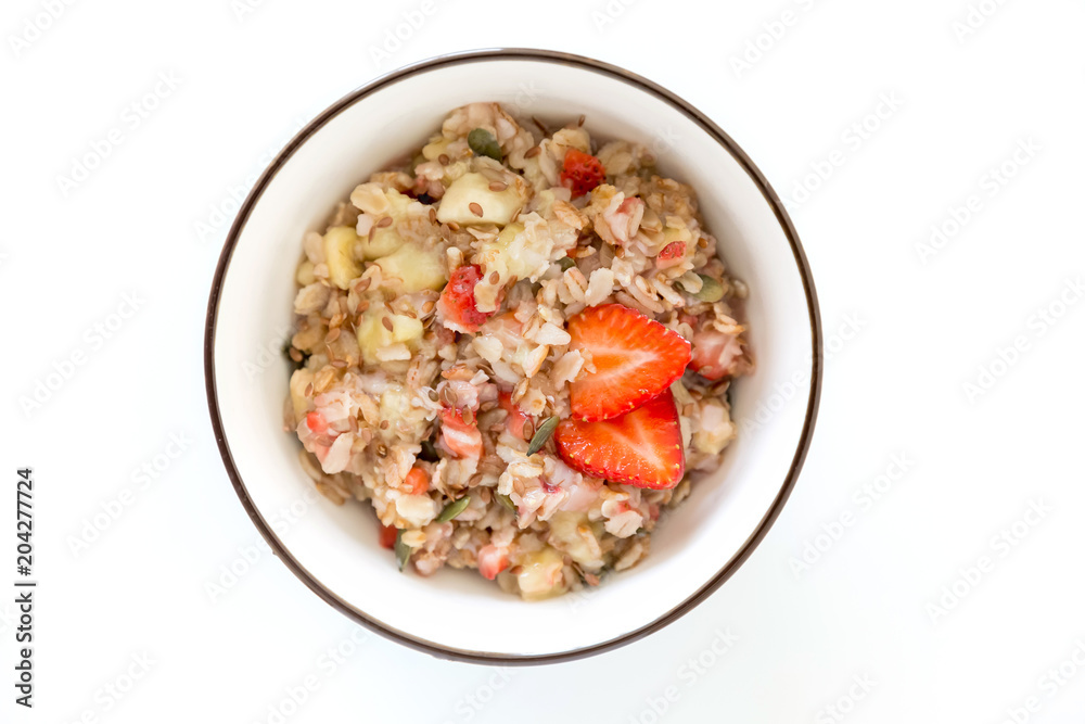 Bowl of healthy oatmeal with fresh strawberries for breakfast. Overhead shot. Bowl of healthy oatmeal with fresh strawberries for breakfast. Overhead shot.