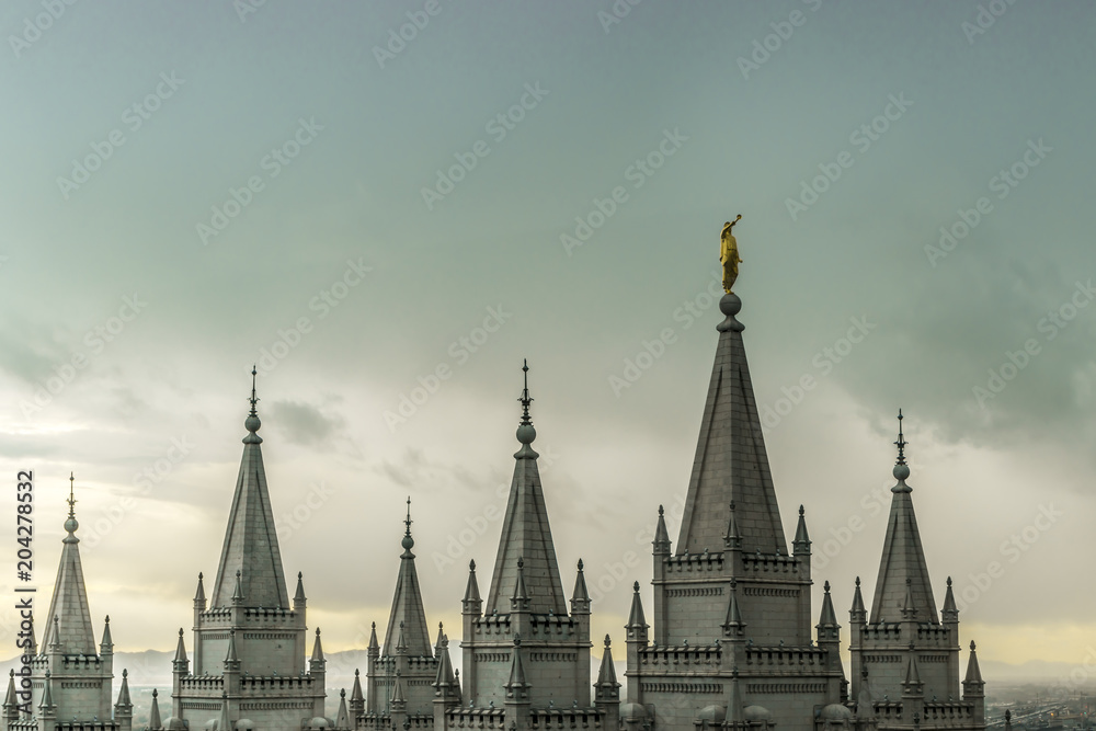 The Angel Moroni and spires of Salt Lake Temple on an overcast spring evening. The Church of Jesus Christ of Latter-day Saints, Temple Square, Salt Lake City, Utah, USA.