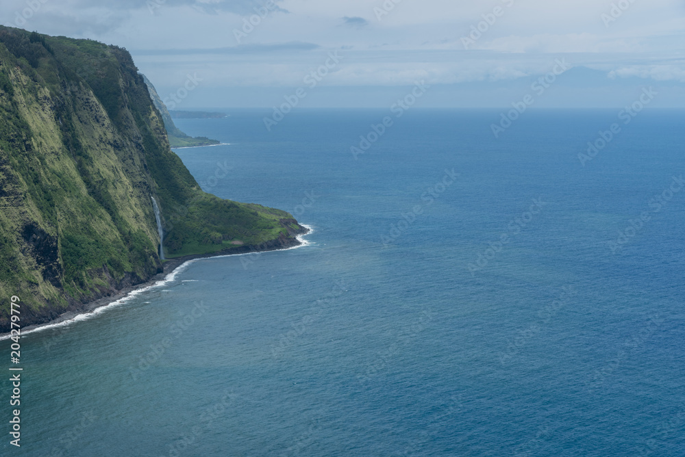 Beautiful Waipio Valley vista on the Big Island of Hawaii with Maui silhouette in the background 