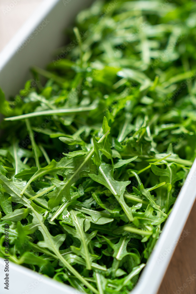 Container of fresh green, natural arugula Container of fresh green, natural arugula