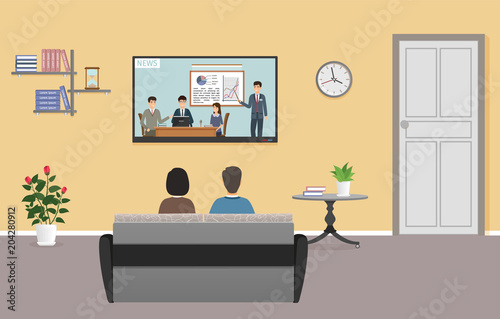Couple of man and woman watching tv in living room interior. Family relax on sofa in front of the tv set. Domestic situation.