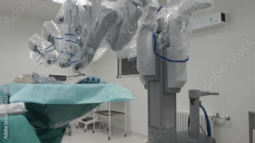 Operating room, medical surgical robot, cancerous tumor removal surgery. Modern medical equipment. Minimally Invasive Robotic Surgery with Surgical System. Helth-control monitor in background