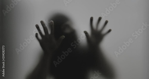 Shadowy figure behind glass / fear, panic concept
