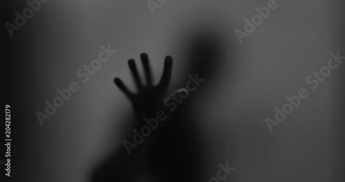Shadowy figure behind glass / fear, panic concept