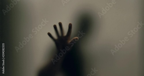 Shadowy figure behind glass / fear, panic concept