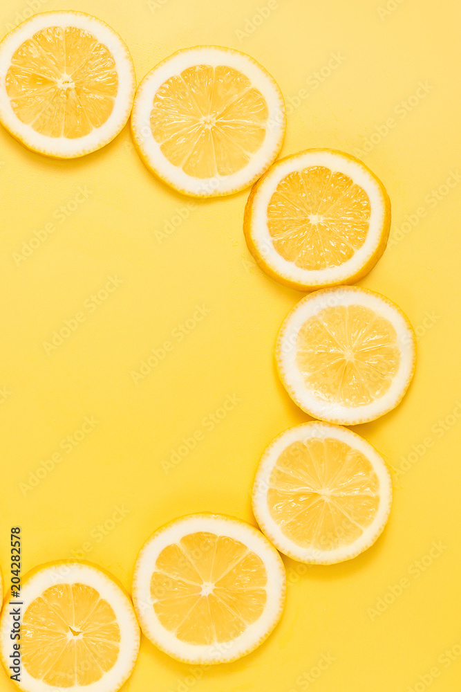 Fresh lemon slices on yellow background. Top view. Place for text. Circle concept.