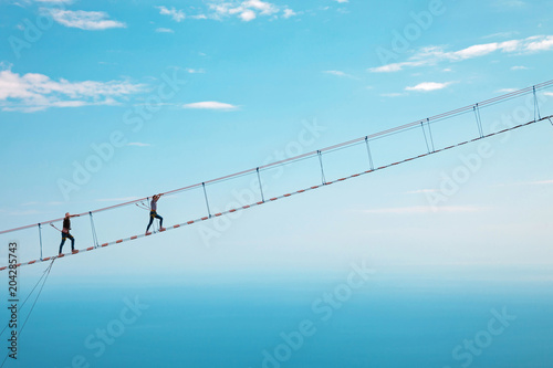 Young woman crossing the chasm on the rope bridge. Ai-Petri, Crimea