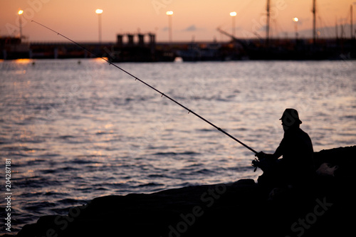 the fisherman at sunset catches fish
