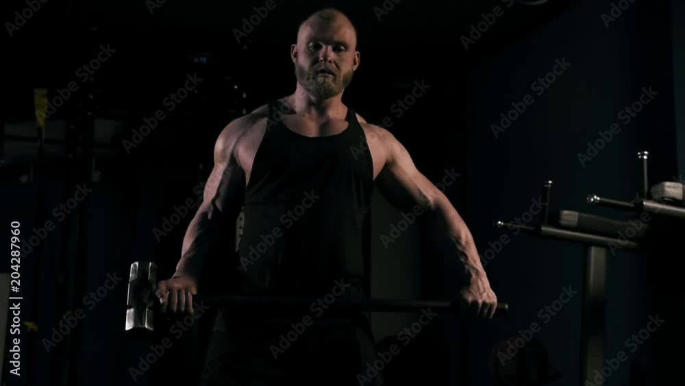Strong man in training with a hammer and wheel Strong man in training with a hammer and wheel