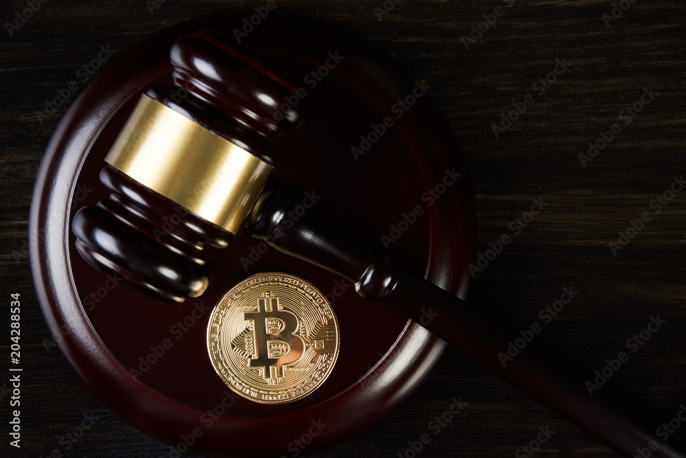 Fototapeta premium Auction gavel and bitcoin on a wooden desk, close-up. Law Gavel and golden bitcoin cryptocurrency money symbol on dark background with copyspace. Crypto currency law theme. Business Internet Concept