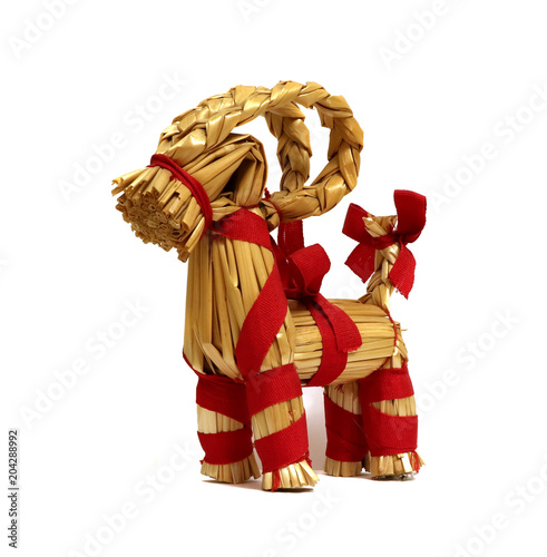  A goat out of straw with a red bow on a white background.      