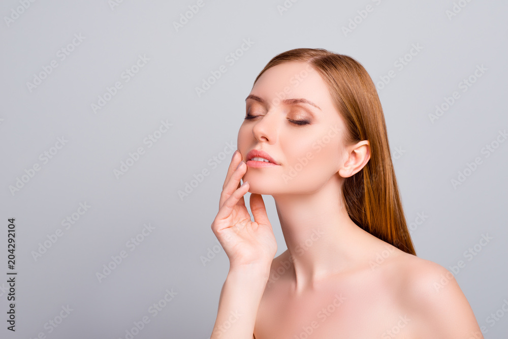 Purity fresh smearing tender correction enhancement soft concept. Perfect side half-faced half-turned portrait of gentle lovely beautiful girl touching her flawless skin isolated on gray background