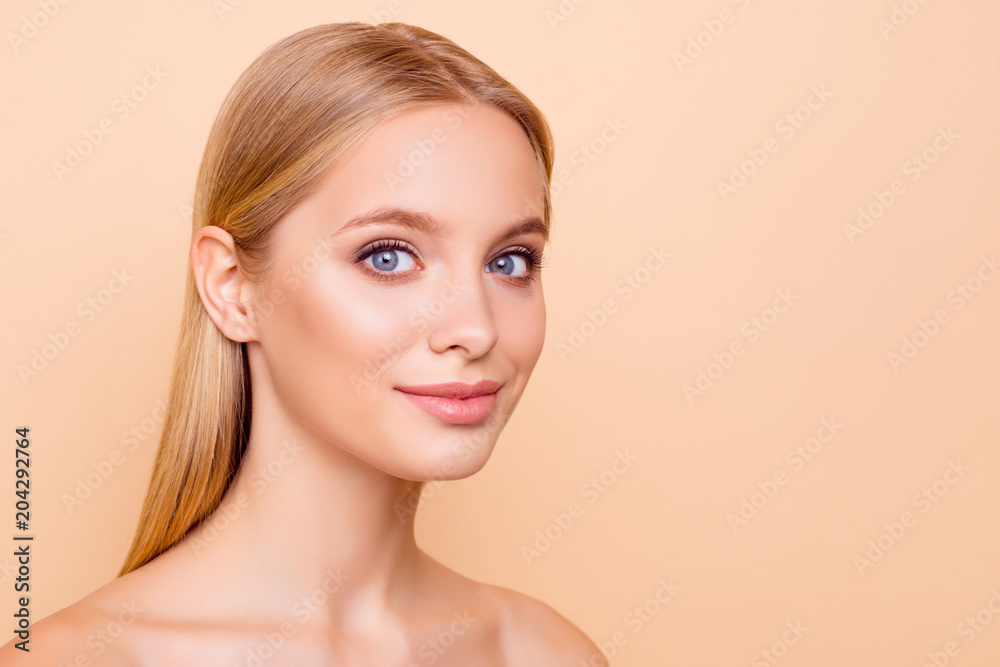 Portrait with copy space empty place of pretty charming cute, natural, half turned girl with plump lips looking at camera having perfect skin isolated on beige background, advertisement concept - obrazy, fototapety, plakaty 