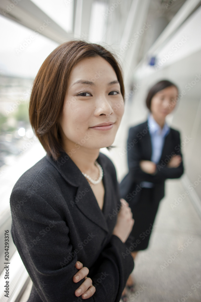 Portrait of Chinese businesswoman with her colleague in the background. Portrait of Chinese businesswoman with her colleague in the background.