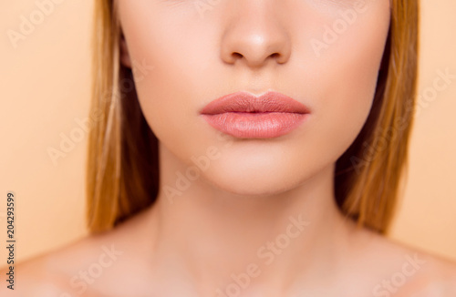 Close up cropped half face portrait of attractive  nude  natural  perfect  ideal girl with soft  healthy smooth lips isolated on beige background  perfection  wellness  wellbeing concept