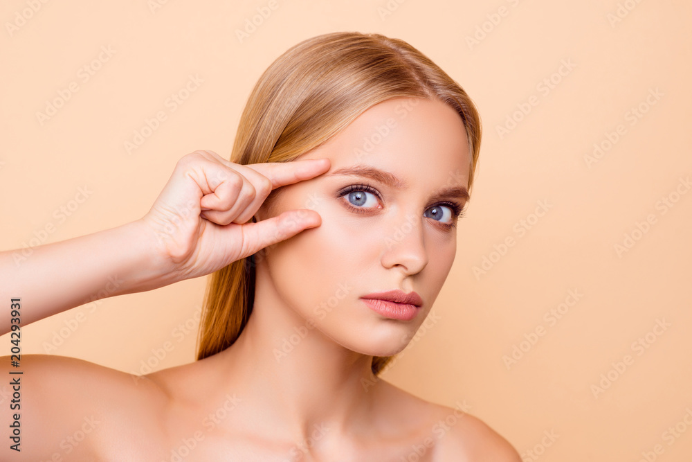 Pretty, charming, cute, nude, natural girl thinking about tightening,  plastic operation, holding fingers near eyes, looking at camera isolated on  beige background, wellbeing, wellness concept foto de Stock | Adobe Stock
