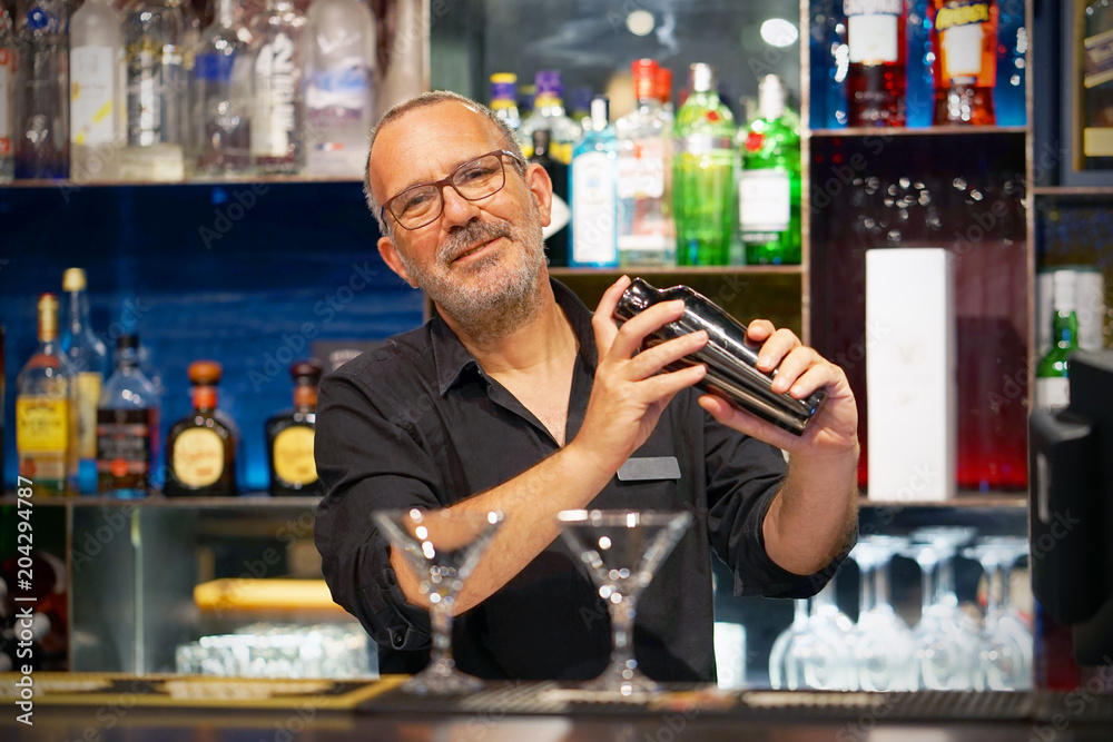 Elderly bartender holding a 