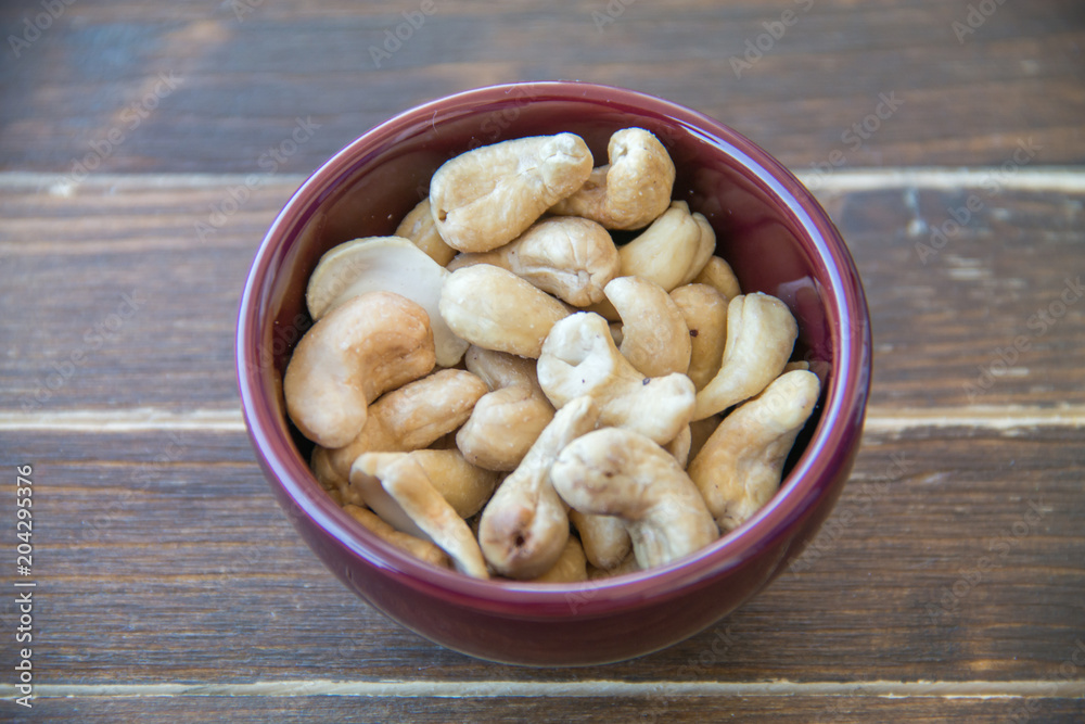 cashew nuts on bowl on a wooden table cashew nuts on bowl on a wooden table