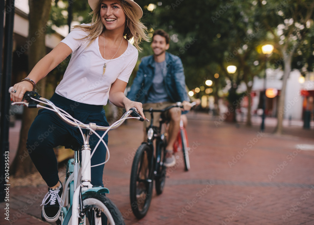 Obraz premium Woman enjoying cycling outdoors with friends