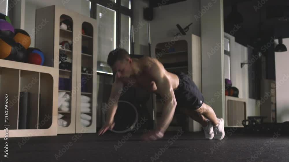 Athletic man doing push ups in gym