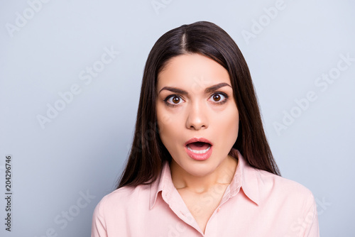 Portrait of shocked, scared, afraid, impressed, stressed, unexpected woman in classic shirt with wide open mouth eyes looking at camera isolated on grey background