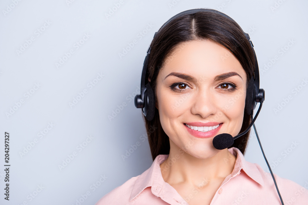 Portrait with copy space of cheerful positive cute woman in shirt with headset and microphone on her head looking at camera isolated on grey background advertisement concept Portrait with copy space of cheerful positive cute woman in shirt with headset and microphone on her head looking at camera isolated on grey background advertisement concept