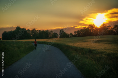 Läufer auf Feldweg im Sonnenuntergang
