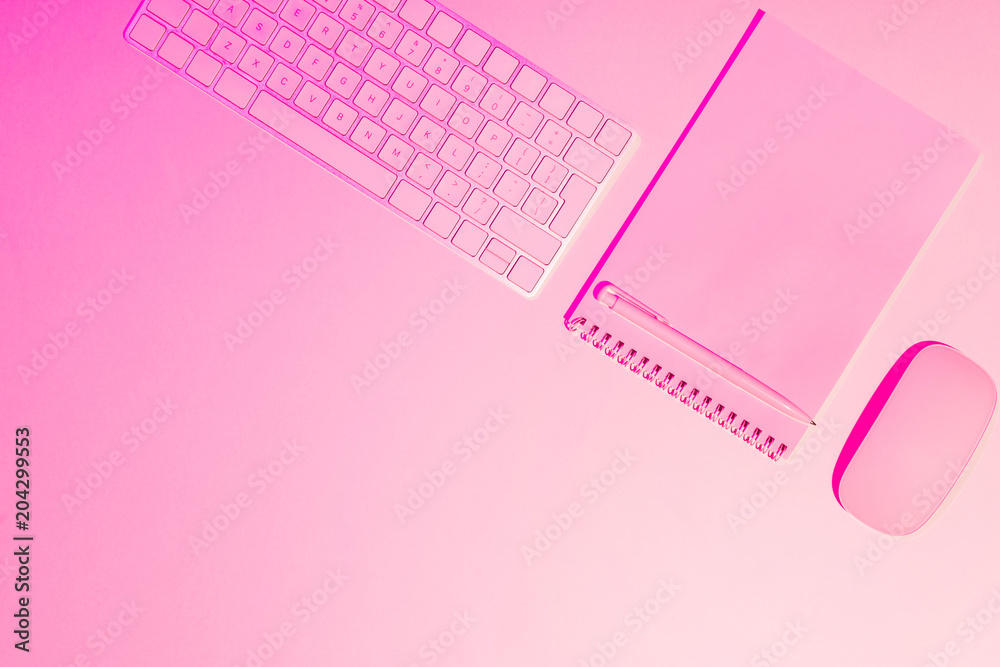 pink toned picture of pen, empty textbook, computer keyboard and mouse on table pink toned picture of pen, empty textbook, computer keyboard and mouse on table